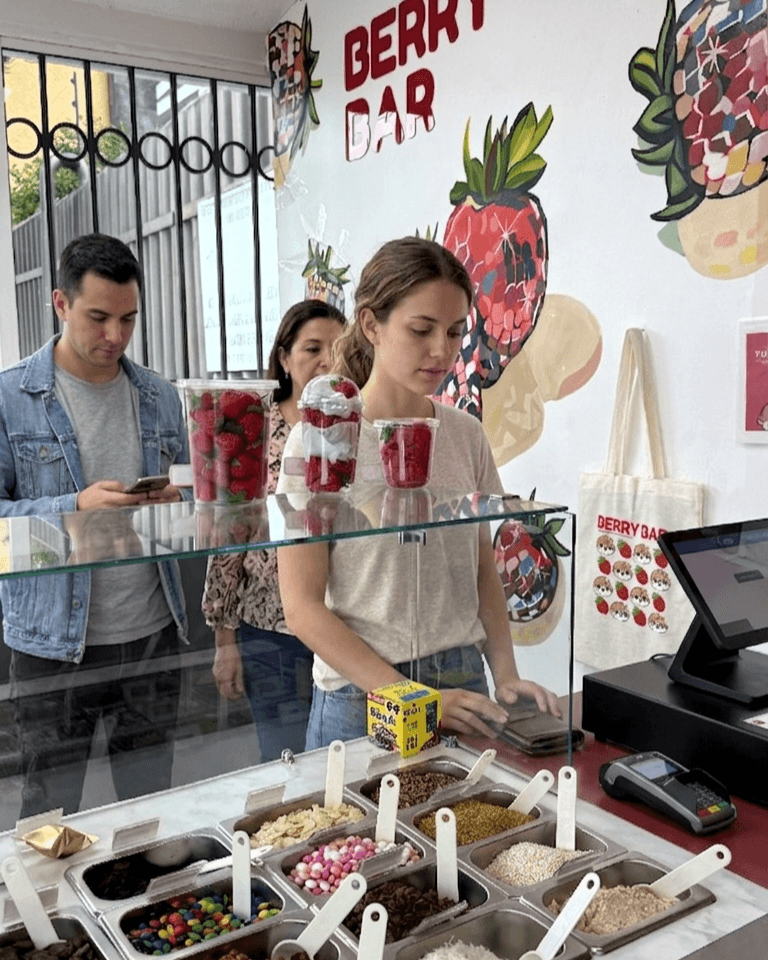 Preparación de fresas con crema en la barra de toppings